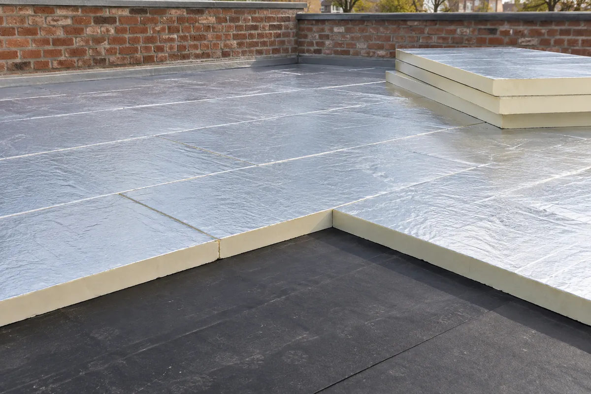 Panneaux isolants rigides à parement aluminium posés sur un toit plat avant étanchéité